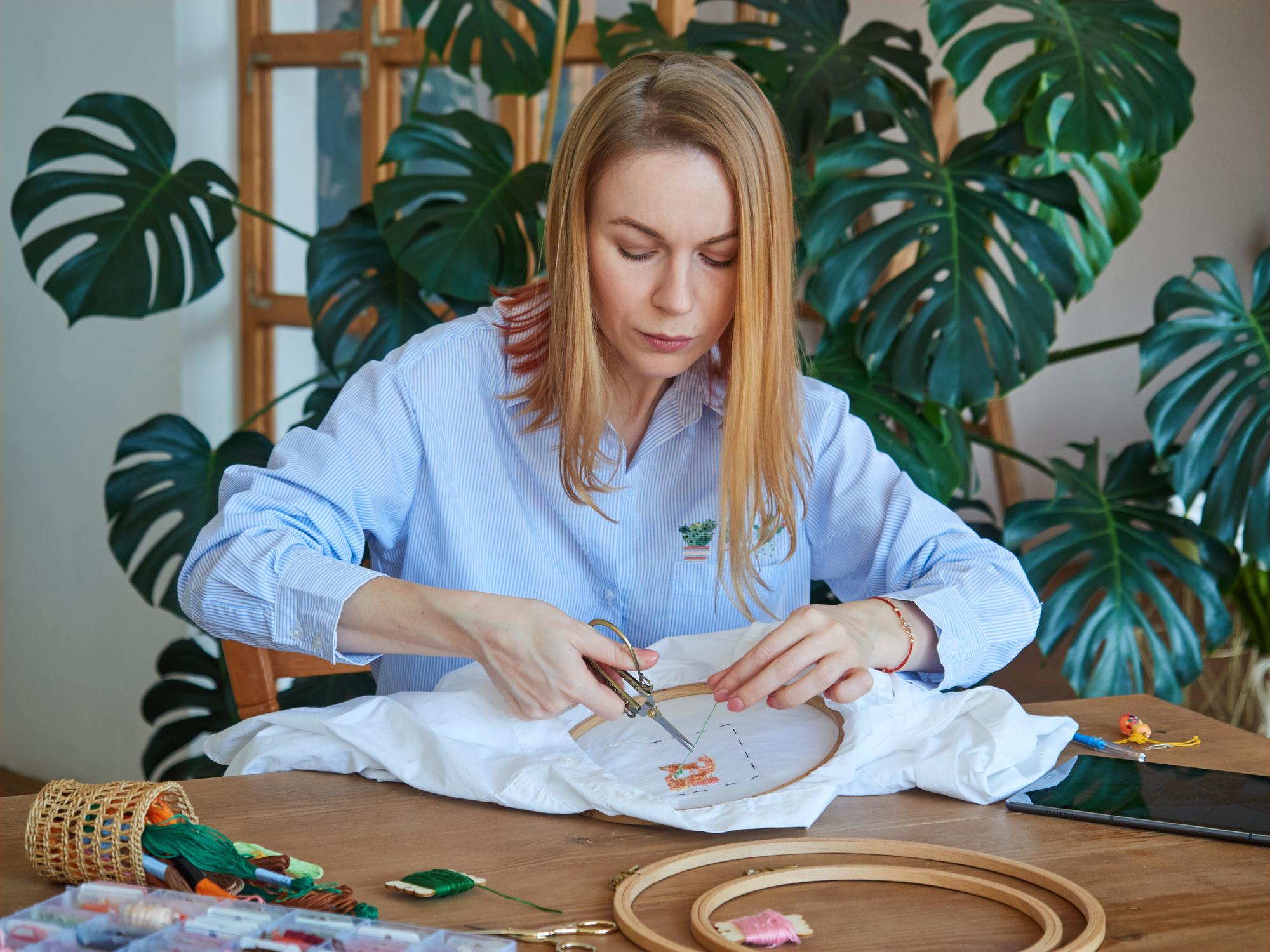 Tutor working on detailed silk embroidery