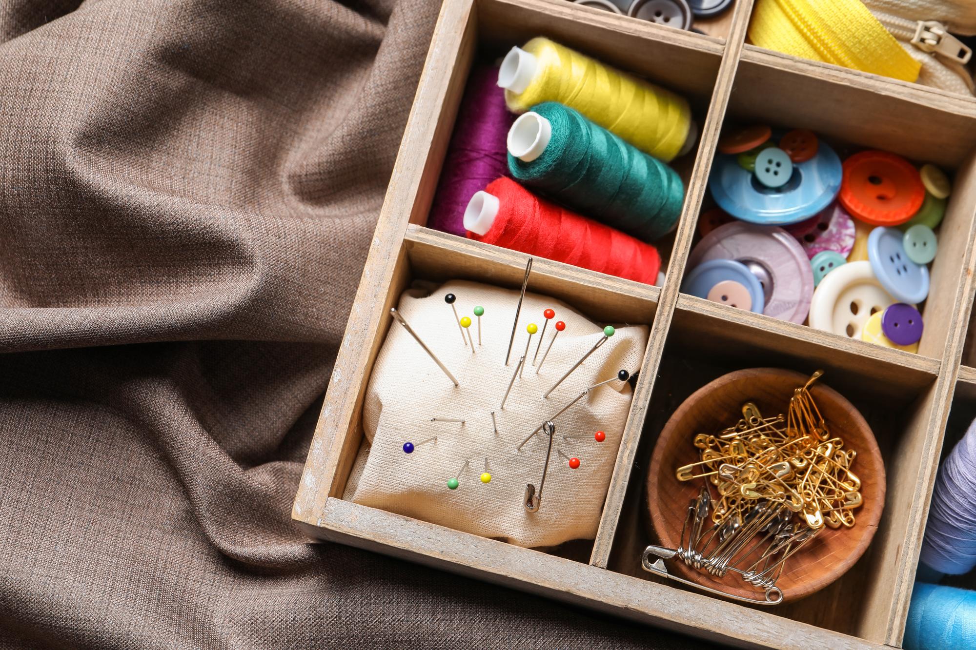 Workspace with threads, needles and sketches